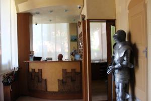 une statue d'un homme debout devant un comptoir dans l'établissement Albergo Al Castello, à Recoaro Terme
