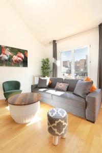 a living room with a couch and a table at Les Lilas Serviced Apartments in Les Lilas