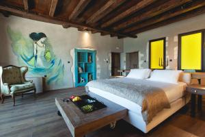 een slaapkamer met een bed en een schilderij aan de muur bij Chania Inn in Chania