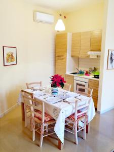 a dining room with a white table and chairs at Brezzolina Apartment with parking in Bitonto