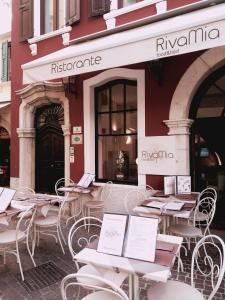 a restaurant with tables and chairs in front of it at Hotel RivaMia in Riva del Garda