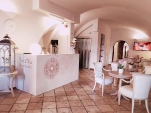 a kitchen with a table, chairs and a refrigerator at Hotel RivaMia in Riva del Garda