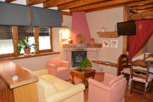 a living room with a couch and a fireplace at Apartamentos Lobiche in Navafría