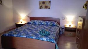 a bedroom with a bed and two lights on two tables at Il Girasole Alloggio in Fluminimaggiore