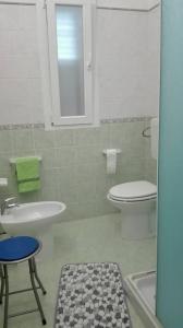 a bathroom with a white toilet and a sink at Il Girasole Alloggio in Fluminimaggiore