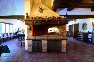 Una gran chimenea de ladrillo en una habitación con mesas y sillas. en Il Collicello en Narni