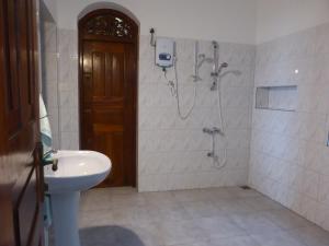 a bathroom with a shower and a toilet and a sink at Villa Sunrise in Tangalle +25 photos