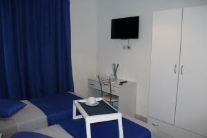 a room with a bed and a tv and a table at Il Rifugio d'aMare in Agropoli +23 photos