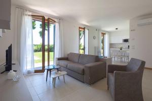 a living room with a couch and a tv and a kitchen at Cà Del Pioppo in Cavallino-Treporti