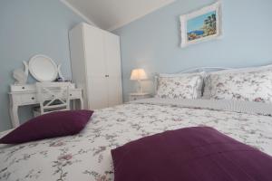 a bedroom with a large bed with purple pillows at House Andrea in Malinska