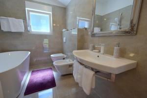 a bathroom with a sink and a toilet and a mirror at House Andrea in Malinska +23 photos