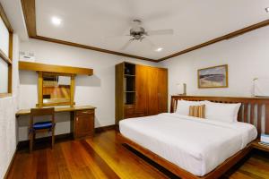 um quarto com uma cama branca e uma secretária em The Strand Boutique Resort em Boracay