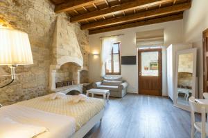 a bedroom with a bed and a stone wall at Casa Dei Delfini in Rethymno