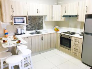 a kitchen with wooden cabinets and white appliances at Dumela Margate Flat No 9 in Margate