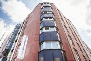 a tall red brick building with a sign on it at Hotel Düsseldorf City by Tulip Inn in Düsseldorf