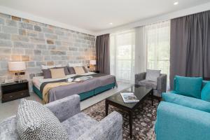 a bedroom with a bed and a brick wall at Hotel Casa del Mare - Amfora in Kotor