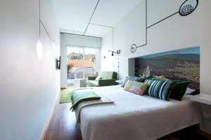 a bedroom with a large bed and a living room at Pensao O Laranjeira in Viana do Castelo