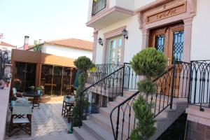 a building with stairs in front of a store at Cunda Svila Otel - Adult Only in Ayvalık