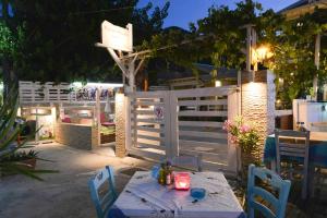a table with two chairs and a white fence at Suites Pierion Musses in Skala Potamias