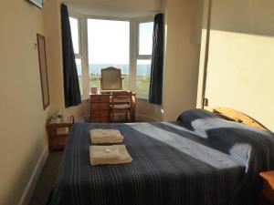 1 dormitorio con 1 cama con 2 toallas en Longbeach- Adults Only en Newquay