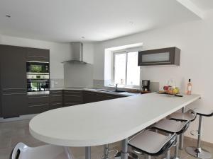 cocina blanca con mesa blanca y sillas en Modern villa with private pool, en Montouliers