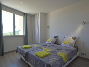 1 dormitorio con 1 cama con mantas amarillas y ventana en Modern villa with private pool, en Montouliers