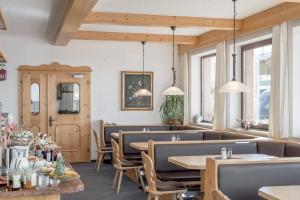 a dining room with tables and chairs and windows at Gasthof Sonne & Schnee in Kühtai in Kühtai