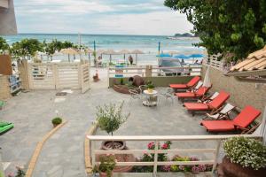 a patio with chairs and tables and the beach at Suites Pierion Musses in Skala Potamias