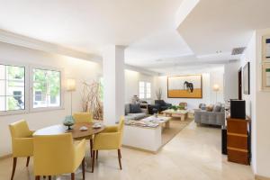 uma sala de estar com uma mesa e cadeiras amarelas em Hotel Patricia Menorca em Ciutadella