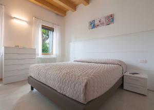 a bedroom with a bed and a dresser and a window at Cà Del Pioppo in Cavallino-Treporti +24 photos