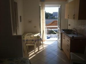a kitchen with a table and a view of a balcony at Casa vacanza in Ponza