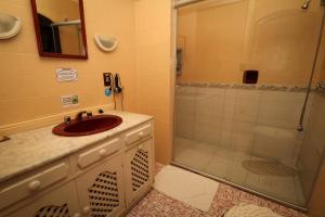 a bathroom with a sink and a shower at Pousada casa da Colina in Gramado