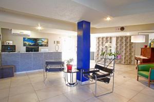 a living room with chairs and a blue pillar at Hotel Funtana Marina in LʼÎle-Rousse