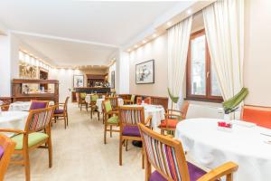 Hotel Duomo في أورفييتو: غرفة طعام مع طاولات وكراسي وطاولة