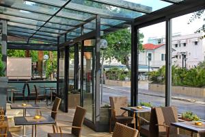 un restaurant avec des tables, des chaises et des portes en verre dans l'établissement Hotel Philadelphia, à Cattolica