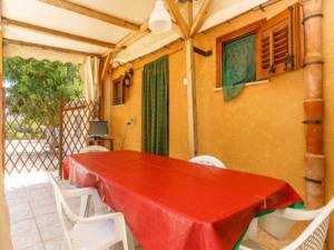 a table with a red table cloth on a patio at Casa Aloha San Vito Lo Capo in San Vito lo Capo
