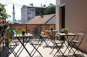 a patio with tables and chairs on a balcony at Hostel Kucha in Sarajevo