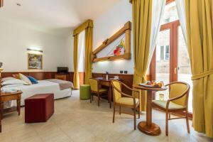 une chambre d'hôtel avec un lit, une table et des chaises dans l'établissement Hotel Duomo, à Orvieto