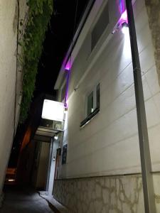 a building with purple lights on the side of it at Rooms Vedran in Mostar