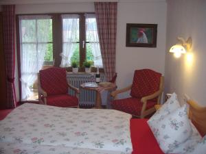sypialnia z łóżkiem, 2 krzesłami i stołem w obiekcie Landhaus Thaumiller w mieście Oberstdorf