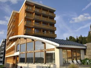 un edificio con grandes ventanas de cristal delante de él en La Berangere, en Chamrousse