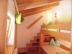 ein kleines Zimmer mit einem Etagenbett und einer Treppe in der Unterkunft Baby- und Kinderbauernhof Montaning in Forstau