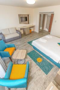 a hotel room with a bed and chairs and a couch at Hotel Riviera in Mamaia