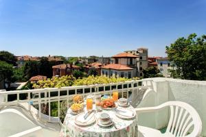 einen Tisch mit Speisen und Getränken auf dem Balkon in der Unterkunft Hotel Biasutti in Lido di Venezia