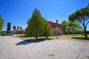 a red house with a tree in front of it at Cà Del Pioppo in Cavallino-Treporti