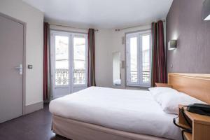 a bedroom with a large bed and two windows at Bonséjour Montmartre in Paris