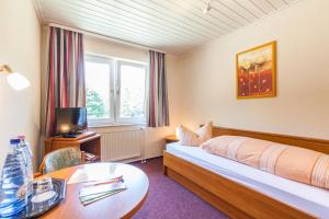 Habitación de hotel con cama y mesa en Sporthotel Wernigerode, en Wernigerode