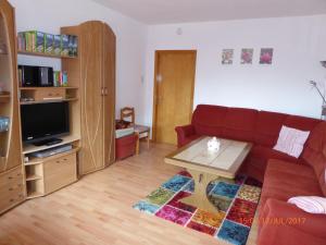 ein Wohnzimmer mit einem roten Sofa und einem Couchtisch in der Unterkunft Schmidtfewo Moorgeist in Bockhorn