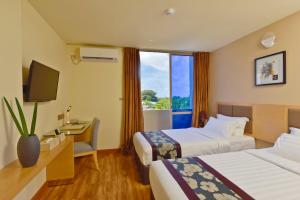 a hotel room with two beds and a television at Season Paradise in Thulusdhoo