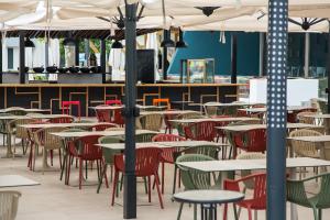 an empty dining room with tables and chairs at Hotel Riviera in Mamaia